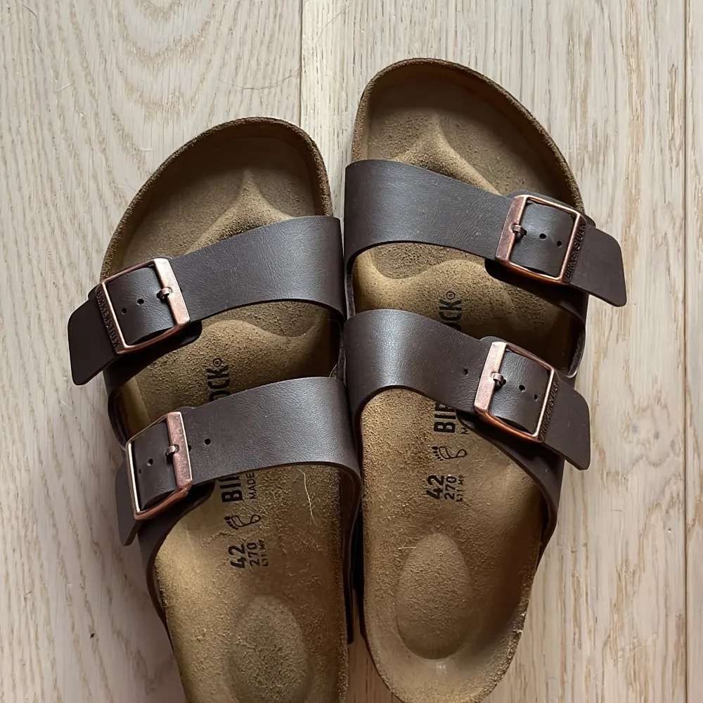 Ett par helt nya birkenstock modell Arizona färg mörkbrun dom är helt nya fick dom i födelsedagspresent men kände att de inte var min still så derför säljer jag dom nypris 1100. Skor.