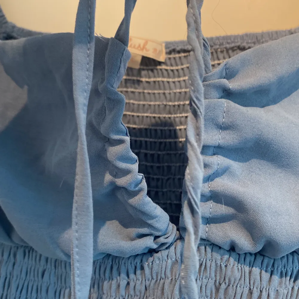 En blå stretchig klänning med knytning vid brösten (se sista bilden) där ena snöret har snurrat sig och inte går att få rakt. Väldigt fin och bekväm klänning nu inför vår och sommar.  Köparen står för frakten🌸. Klänningar.