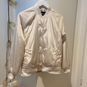 Jacka - Beige täckjacka med vita ränder på muddar