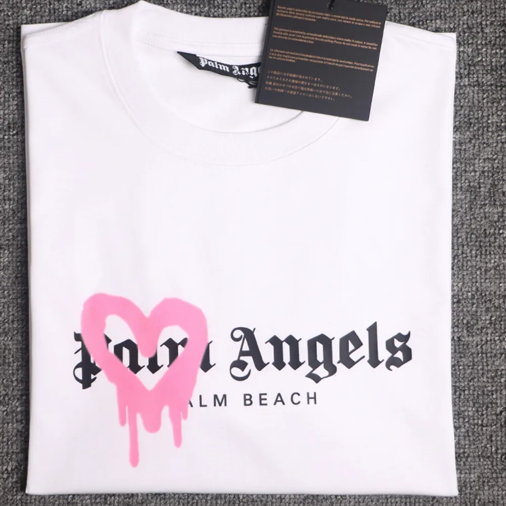 Vit Palm Angels T-shirt med ett rosa hjärta💗Använd 1 gång, Strl M, Nypris 2999. QR-kod finns och den kommer med påsen och alla lappar!. T-shirts.