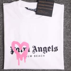 Vit Palm Angels T-shirt med ett rosa hjärta💗Använd 1 gång, Strl M, Nypris 2999. QR-kod finns och den kommer med påsen och alla lappar!