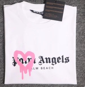 Palm Angels T-shirt  - Vit Palm Angels T-shirt med ett rosa hjärta💗Använd 1 gång, Strl M, Nypris 2999. QR-kod finns och den kommer med påsen och alla lappar!