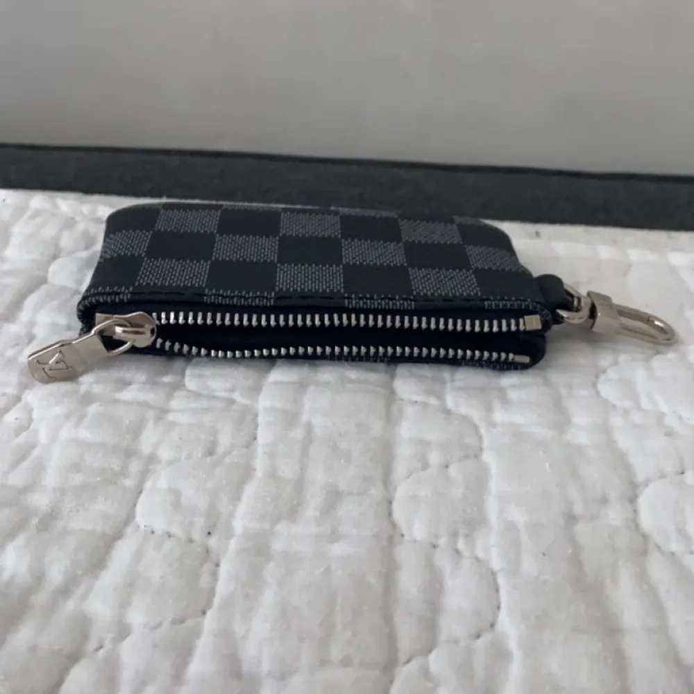 En mini lv bag som tillhörde en Messenger bag, man kan sätta fast den på jeans, tröja eller väska om man vill. Knappt använd, du får plats me kort eller pengar i den. (kopia såklart) . Accessoarer.