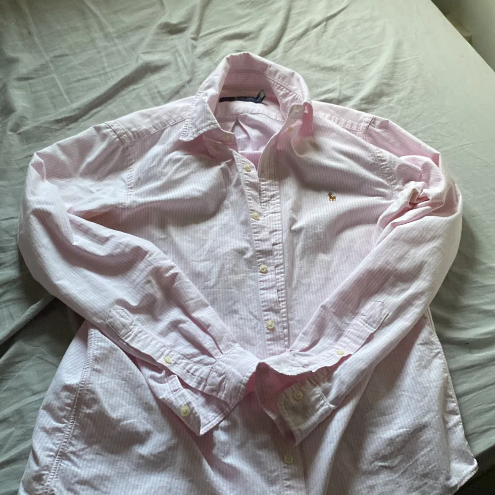 Säljer denna rosa Ralph lauren skjorta pga att jag inte använder den och behöver pengarna. Dock håller den vita färgen att fadea bort på några ställen av skjortan men det är inget man märker. Pris går att diskutera . Skjortor.