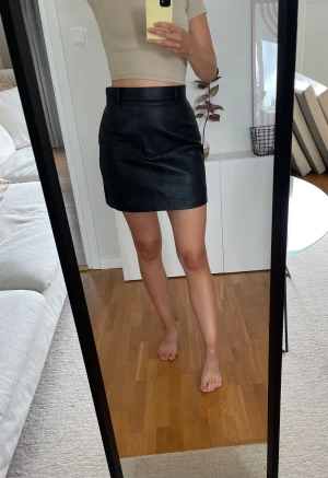 Kjol i lädermaterial från H&M  - Kjol i läderimitation från H&M. Storlek 36, bra skick!