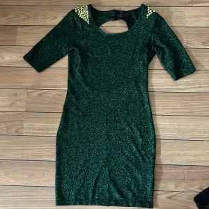 Grönglittrig klänning med axelvadd. Använd 1 nyår