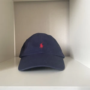 Blå ralph lauren keps - Äkta ralph lauren keps med QR-kod. Ny pris 495kr.
