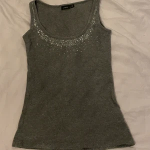 topp - jätte söt grå topp med detaljer på framsidan! fin passform!