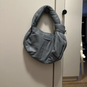 Väska från Day - Liten axelväska från Day. Ny aldrig använd är i en blå/grå färg.