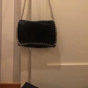 Svart Tiamo axelväska - Svart modell större crossbody axelväska från Tiamo. Jättefint skick. Kommer inte till användning längre.