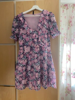 Blommig klänning  - Väldigt fin blommig klänning, den är i bra skick, finns 1 söm som har släppt lite, skicka till mig så kan jag skicka bild på den. Den har volang och puffiga armar. 