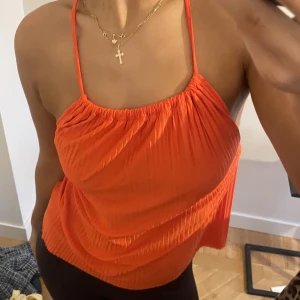 Orange halterneck topp med öppen rygg - Säljer denna helt oanvända halterneck topp i VÄRLDENS snyggaste orange / korall färg. Kan kläs både upp och ner❤️