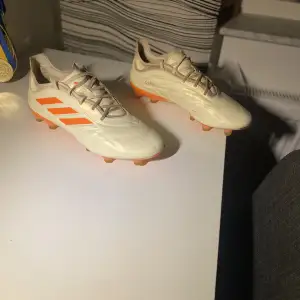 Jag säljer ett par adidas copa pure .1 fotbollsskor som jag använt i cirka 3 månader!  Skicket är som nytt förutom de defekter som visas på bild 2. Det som har hänt är att lädret spruckit men det är inget man känner av när man spelar Strl.40 2/3 (25,5 cm)