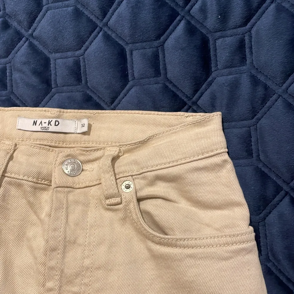 Snygga beigea high waisted jeans från NA-KD i storlek 32. Den har en knappgylf istället för en dragkedja. Skit fina och i väldigt bra skick. Jeans & Byxor.