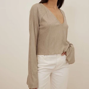 Plisserad blus  - Plisserad elegant blus med längre trumpet armar 