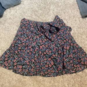 Blommig kjol - Blommig kjol som knyts med en rosett. Aldrig använd☺️