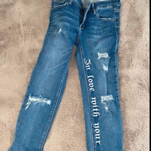 Jeans med text och slitningar 