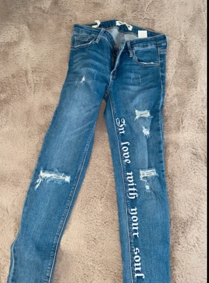 Jeans - Jeans med text och slitningar 