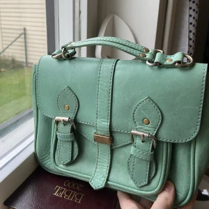 Turkos väska från Rules by mary  - Relativt liten väska perfekt för mobil, nycklar osv! Har små tecken på användning. Vintage väska 