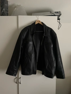 Trendig läderjacka  - Trendig läderjacka i str XL. Svart insida och svart läder. Tyvärr är dragkedjan ur funktion men inget som stört mig!