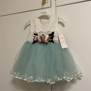 Klänning  - En ljus blå fest klänning för barn mellan 9-15 månader. 