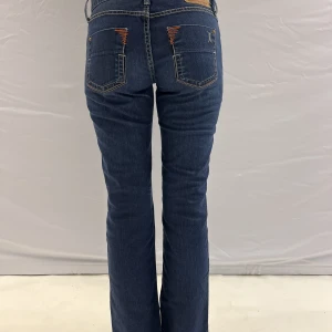 Mörkblåa fornarina jeans - Mörkblåa Fornarina lågmidjade jeans som är uppsprättade och har slits💓