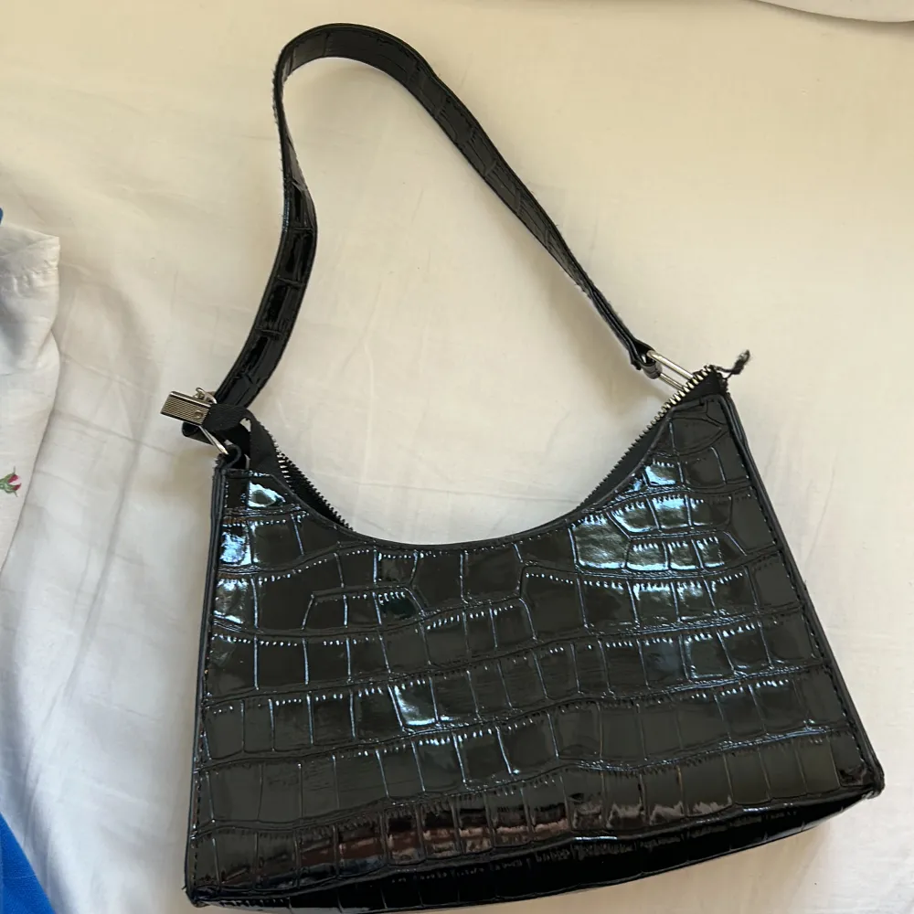 - En liten svart väska med glansigt material - Använd fåtal gånger men är i väldigt bra skick - Från SHEIN - säljer för 50kr+frakt . Laukut & Käsilaukut.