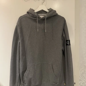 Calvin Klein Hoodie - Grå Calvin Klein Jeans hoodie i storlek M. Endast använd ett fåtal gånger så fortfarande i väldigt bra skick. Nypris 999 kr  Priset är ej hugget i sten