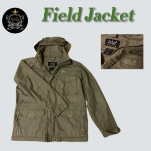 Field Jacket - Sjukt snygg field jacka från Jack Wolfskin. Denna jacka har en luva som är inbyggd i kragen, som går att ta bort  (se bild 2). Nypriset på denna jacka ligger på över 4000 kr (se bild 3). Skick: 8.5/10, finns inga hål, slitage osv. 