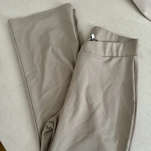 Mjuka byxor  - Beige byxor från Nelly med slits i midjan. Använda men i bra skick🌸 