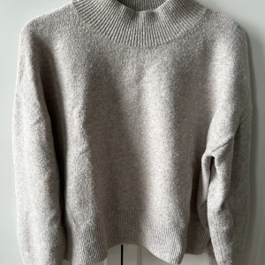 Beige stickad tröja - Stickad tröja från &other stories. Den är pyttelite croppad och har lite högre halsmudd. Jätteskön och mjuk!