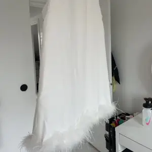 Säljer denna vita klänning med fjädrar jag aldrig använt 