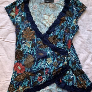 blommig topp - skiiiitsnygg, skriv för att se bild på, den sitter super, och är jätte flattering, den har sjukt söta spetsdetaljer oxå, den är XS men passar S oxå