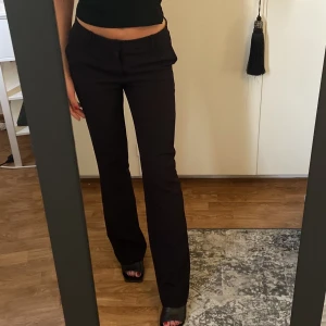 Lågmidjade kostymbyxor  - Svarta lågmidjade kostymbyxor från NEONOIR/Nelly! Aldrig använda, endast testade. Säljer då jag har flera liknande och kunde inte retunera. Nypris,  699kr! 