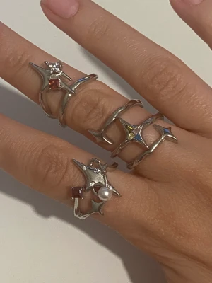 Y2k Ringar - Y2k ringar från designmärket Sumiyaki. Köpta för 349kr styck. Vill du bara köpa 1 så skriv till mig så ordnar vi det! Original värde tot 1047kr. Öppna ringar så att man kan anpassa storleken. Gjorda av silver🤍Original förpackningar finns. 650kr för alla 3