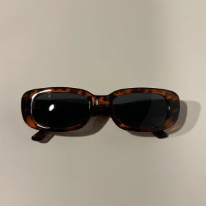 Solglasögon - tortoise  - Oanvända solglasögon. Tortoise (brun/svart) med svart glas.   Solglasögonfodral (svart) medföljer utan extra kostnad. 