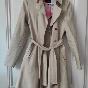 Ted Baker trench coat - Beige Ted Baker trench coat i bra skick. Rose gold färg i detaljerna. Storlek 1 som motsvarar 36 / S.