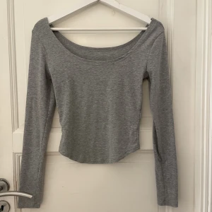 tröja  - grå långärmad tröja som nästan är ”off shoulder” men kan absolut vara som en helt vanlig tröja om man vill det😊