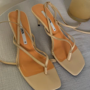 Klackar  - Superfina klackar från Zara som man knyter längs fotlänken, oanvända, endast provat dem inomhus färgen är orange/beige. Säljer på grund av att de är för stora för mig. Storlek 39