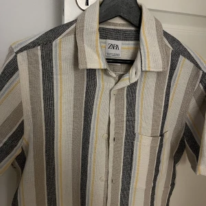 Zara piké skjorta - Randig piké skjorta från Zara nypris 399. Aldrig använd. Perfekt till sommaren med lite struktur i materialet. Passar S/M