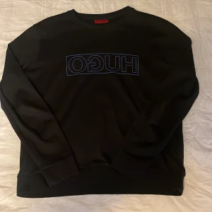 HUGO tröja Svart med blått märke - En HUGO tröja som knappt är använd, inga skador och till ett bra pris. Säljer då den ej passar.