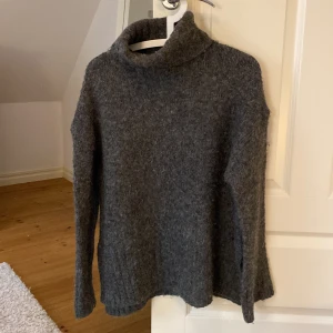 Stickad polokrage - En jätteskön grå stickad polotröja med slits på sidorna, otroligt skön och har därav använts men är fortfarande i bra och acceptabelt skick💙 Frakt ingår i kostnad