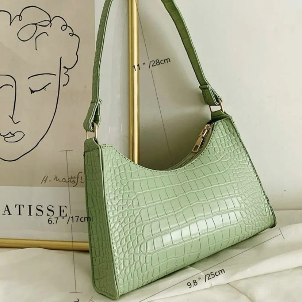 En grön handväska i ”ormskinn” med en guld dragkedja. Hör av er vid frågor och vid snabb affär kan priset sänkas:). Väskor.