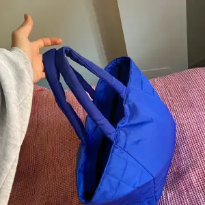 Blå puffer väska