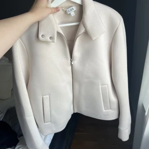 Beige kappa från COS - Passar inte mig så säljer vidare, superfint skick. Storlek S. Knappt använd, nypris över 1000kr