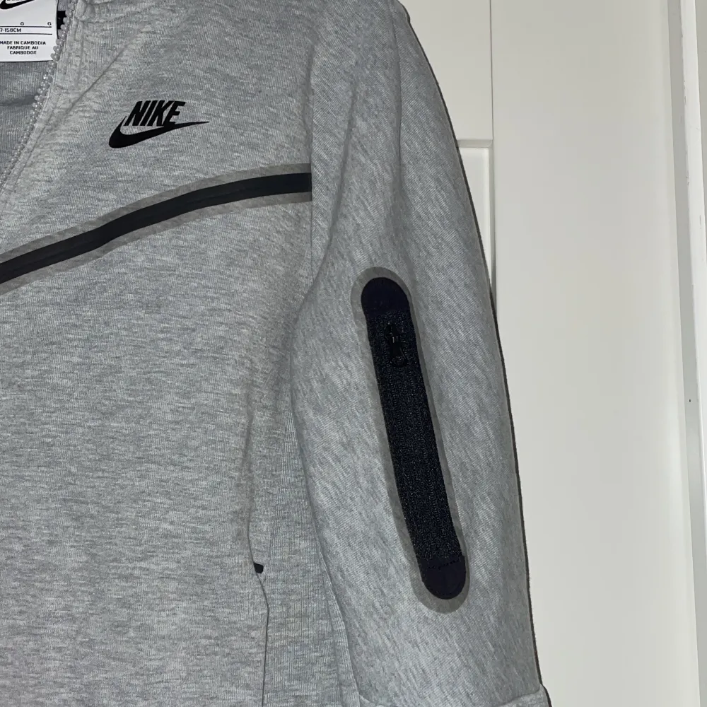 Detta är en barn Nike tech fleece som är storleken 147-158cm. Den är använd Max 3 gånger då den vart för liten snabbt. . Tröjor & Koftor.