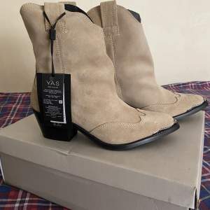 Yaspitla Western Boots Creme mocka  Nyskick, direkt från butik och ALDRIG använda.   Orginal pris 1500kr  För mer bilder och förhandlingar skriv!  8 par inne!  Storlekar: *40 *39 *38 *38 *38 *37 *37 *36 ……………………………………………………………………. 