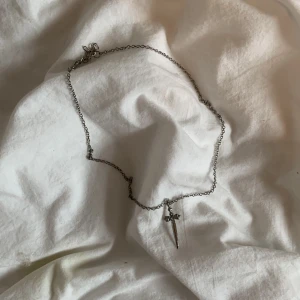 Silvrigt halsband - Silvrigt halsband med ett litet svärd på, knappt använd, inte riktigt silver och jag kommer inte ihåg vart den är ifrån🤍