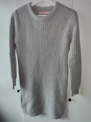 Grå stickad klänning  - Bekväm grå stickad klänning. Går lite ovanför knäna på mig (165 cm). Har för mig att den är från Ullared eller liknande, storlek 146/152 passar även Xs samt liten S