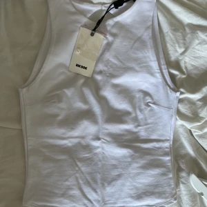 Body med öppen rygg - Body med öppen rygg från bikbok som inte längre går att köpa. Aldrig använd, prislappen är kvar. Storlek xs men passar s. (Liknar den på bilden, men är kortärmad och har inget band i mitten av ryggen). Säljer även en likadan body i svart 